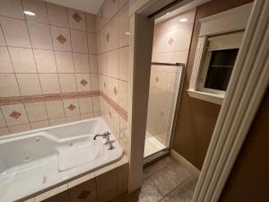 a bathroom with a bath tub and a shower at Riverside Pool Chalet ! in Clarkes Beach +22 photos