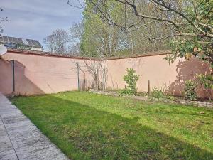 a wall with a grass yard next to a building at Maison familiale in Rueil-Malmaison