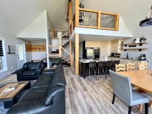 a living room and kitchen with a couch and a table at Chalet Desroy in Chertsey