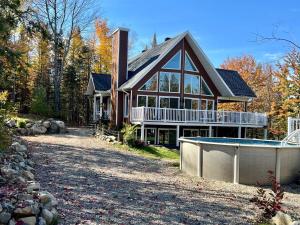 a house with a swimming pool in front of it at Chalet Desroy in Chertsey