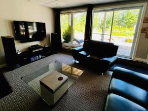 a living room with a couch and a chair and a tv at Chalet Desroy in Chertsey