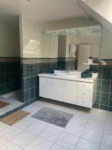 a bathroom with a sink and a large mirror at BY NEPTUNE - La Maison Courtenay Piscine Privée, 4 Chambres in Courtenay
