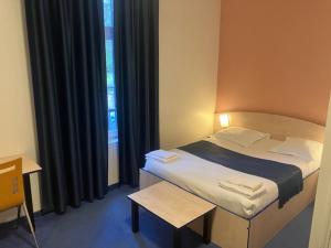 a hotel room with a bed and a window at Hotel César Centre-ville Gare Charleville-Mézières in Charleville-Mézières