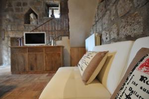 ein Wohnzimmer mit einem weißen Sofa und einem TV in der Unterkunft Country House La Torre in Tuscania