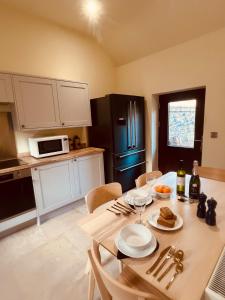 a kitchen with a table with plates and wine glasses at Gardener's Cottage in Coldstream Station