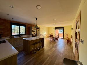 a large kitchen and living room with wooden floors and chairs at VILLA RINCON DEL BUITRE in Moratalla