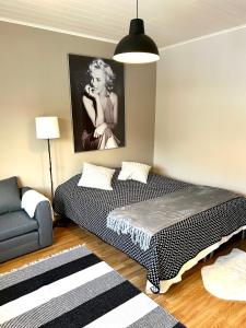 a bedroom with a bed and a couch and a picture at Yksiö Jyväskylässä keskustan tuntumassa in Jyväskylä