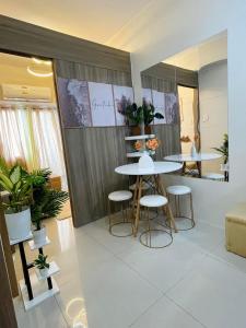 a dining room with two tables and stools in a room at King Elite Condo Hotel Field Residences Near NAIA Airport in Manila