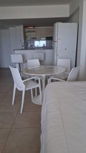 a table and chairs in a room with a kitchen at COSTA y MAR in Villa Gesell +11 photos