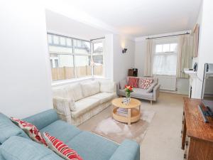 a living room with two couches and a table at Framingham in South Hayling