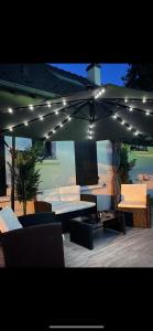a patio with an umbrella and chairs and a table at BY NEPTUNE - La Maison Courtenay Piscine Privée, 4 Chambres in Courtenay