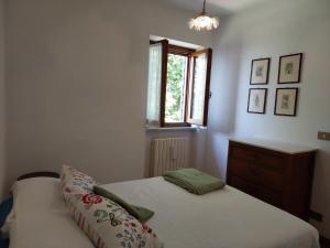 a bedroom with a bed and a dresser and a window at Casa Peppina in Strettoia