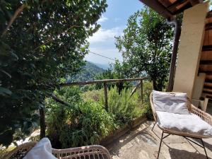 a balcony with two chairs and a view of the mountains at Casa Peppina in Strettoia