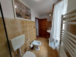 a bathroom with a toilet and two sinks at Casa Peppina in Strettoia +22 photos