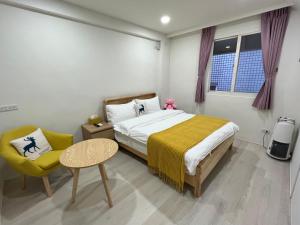 a bedroom with a bed and a chair and a table at Dongzi Dongzi Wellness B&B in Wujie +22 photos
