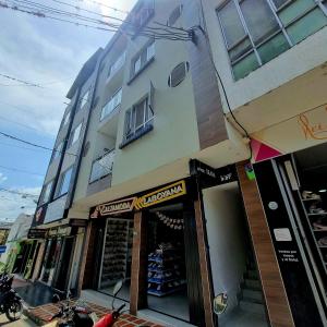 a store front of a building with a motorcycle parked outside at Hotel Iloa in Pitalito