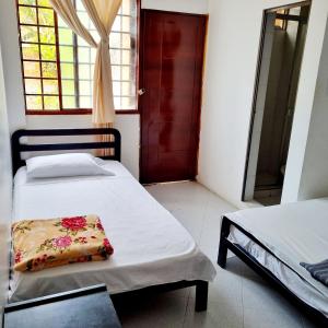 a bedroom with two beds and a red door at Hotel Iloa in Pitalito