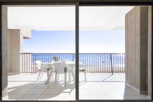 a table and chairs on a balcony with a view of the ocean at RIURAU HOME 1ª línea Calpe-Playa II in Calpe