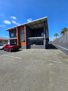 a building with a red truck parked in a parking lot at 33onBazley Hotel in Durban