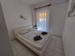 ein Schlafzimmer mit einem Bett mit zwei schwarzen Handtüchern darauf in der Unterkunft Cozy Sun in Polychrono