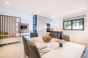 a dining room and kitchen with a white table and chairs at Old Town Charm Apartment in Albufeira