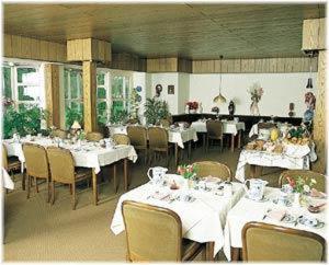 un comedor con mesas y sillas blancas en Landhotel Ridder en Bad Laer