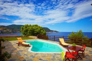 スコペロスにあるPorto Skopelos Villasの海の景色を望むスイミングプール(椅子、テーブル付)