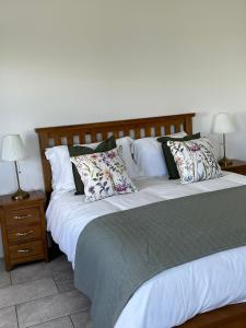 a bedroom with a large bed with pillows at Andy's Cottages at the Well in Hilltown