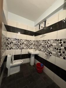 a bathroom with a toilet and a sink at Royal Guest House in Almora