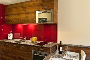 eine Küche mit roten Wänden und einer Theke mit einer Spüle in der Unterkunft Studio Castor Zermatt in Zermatt
