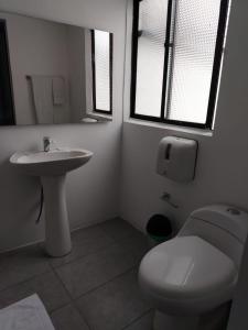 a white bathroom with a toilet and a sink at Donde Emilio in Pereira +14 photos