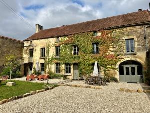 un antico edificio in pietra con tavolo e sedie di Maison Marguerite, Maison de Charme,jacuzzi a Gigny