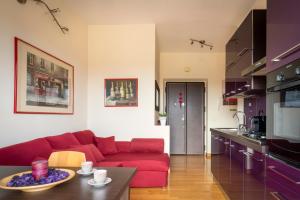 a living room with a red couch in a kitchen at Vatican Charm Retreat in Rome