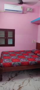蒂鲁瓦纳马莱Sree Akshayam Rest House 2 bhk的卧室里有一张床，床铺是红色的