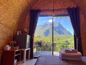 a bedroom with a large window with a view of a mountain at ลุงพล โฮมสเตย์ เชียงดาว in Chiang Dao