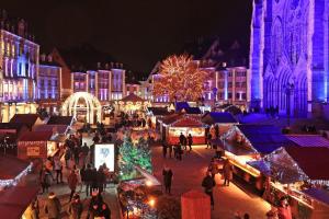 a group of people walking around a christmas market at night at Studio Cocon in Lingolsheim