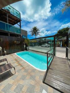a swimming pool in front of a building at Pousada Tropical Maragogi in Maragogi