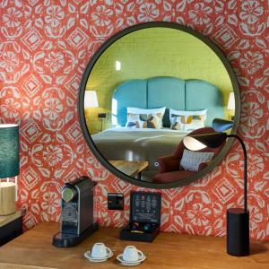 ブリストルにあるホテル ドゥ ビン ブリストルのベッドと電話付きの部屋の鏡