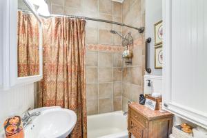 a bathroom with a tub and a sink and a shower at Walk to the Strand Hideaway Haven Retreat in Galveston +23 photos