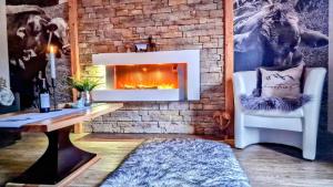 プフロンテンにあるFerienwohnungen Wolf - Wohnung" Kienberg" mit Bergblickの暖炉とテーブルと椅子のあるリビングルーム