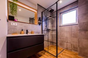 a bathroom with a sink and a shower at Charming Loft Ferienwohnung Bodensee in Meckenbeuren +39 photos