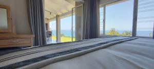 a bedroom with a bed with a view of the ocean at 4 Chaka's Rocks Chalets - The Beach Cottage in Ballito +35 photos