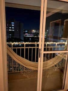 a window with a hammock on a balcony at night at Next to the Mall - Air Conditioning in São José dos Campos