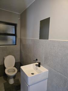 a bathroom with a white toilet and a sink at Millennial Arch in Langebaan +7 photos