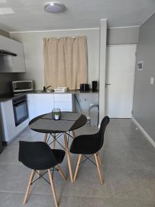 a small kitchen with a table and two chairs at Millennial Arch in Langebaan