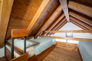 a bedroom with two bunk beds in a wooden attic at Baita Iadi - Villaggio dei Crodini in Cravegna