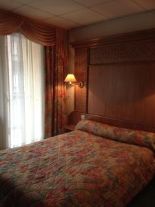 a hotel room with a bed and a window at Hotel Union in Sarreguemines