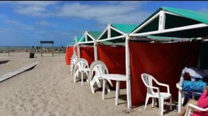 a group of chairs and umbrellas on the beach at DIVMAR APART Santa Clara del Mar in Santa Clara del Mar
