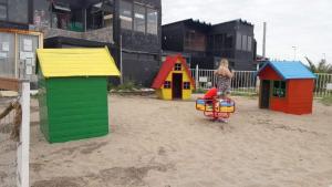 a child playing on a playground with colorful play structures at DIVMAR APART Santa Clara del Mar in Santa Clara del Mar