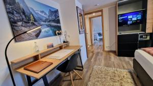 a room with a desk and a bed at Ferienwohnungen Wolf - Wohnung "Falkenstein" mit 3 Zimmer in Pfronten